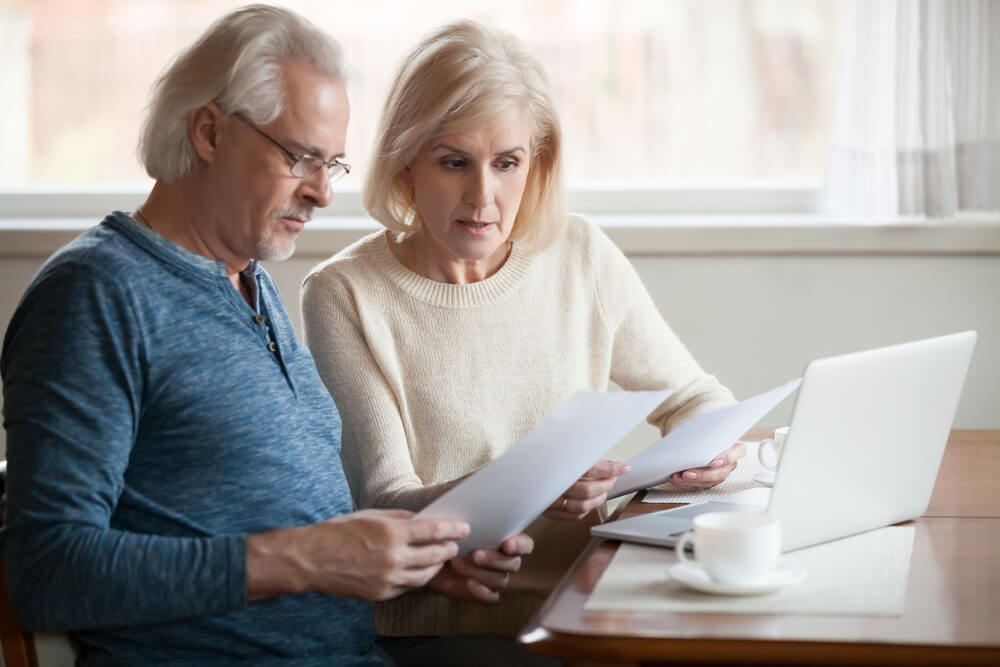 older caucasian couple looking at documents and finances before getting divorced