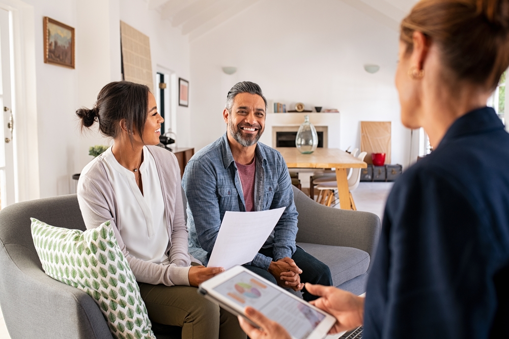 couple smiling while talking to their lawyer about estate planning