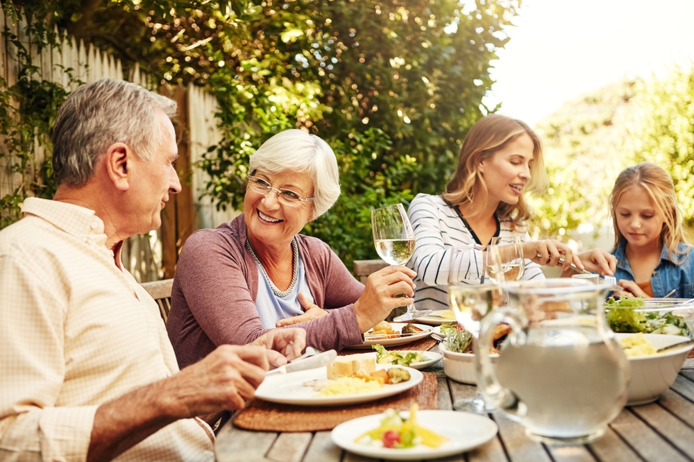 grandparents with daughter and grandchildren eating dinner